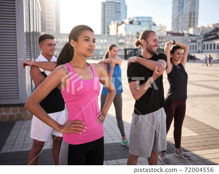 Team of young mixed race sportsmen doing warm up Team of young mixed race sportsmen doing warm up 72004556