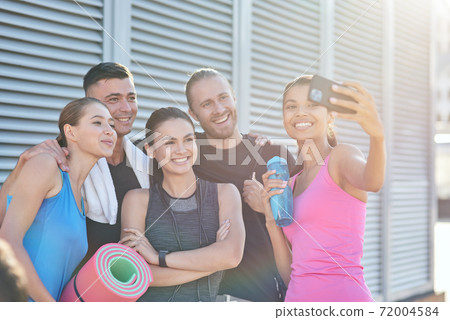 Happy sport team taking selfie on building wall background Happy sport team taking selfie on building wall background 72004584