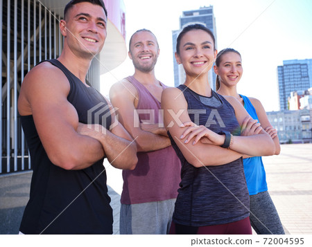 Happy young caucasian fitness team with crossed hands Happy young caucasian fitness team with crossed hands 72004595