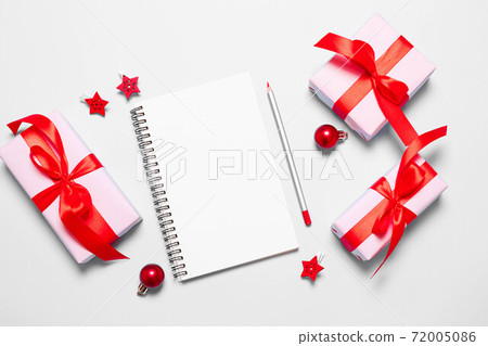Planning and setting goals for the next year. New Year goals List 2021 with white notebook written plan. Christmas gift box wrapped in pink paper with red ribbon Planning and setting goals for the next year. New Year goals List 2021 with white notebook written plan. Christmas gift box wrapped in pink paper with red ribbon 72005086