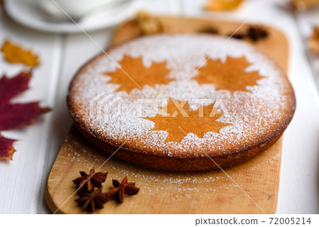 Beautiful fresh sweet pumpkin cake with a maple leaf pattern on a white wooden background 72005214