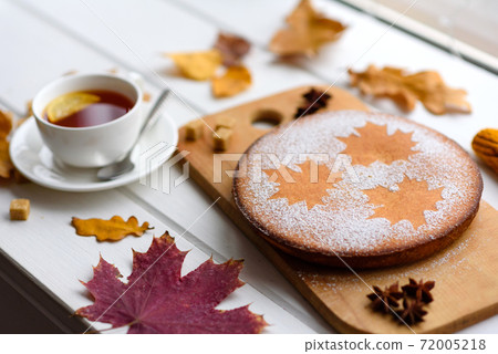 Beautiful fresh sweet pumpkin cake with a maple leaf pattern on a white wooden background 72005218
