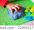 Child playing in kinetic sand 72005517