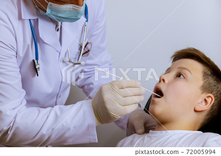 Medical worker to check in teenager on mouth swab for PLR test coronavirus for Covid-19 Medical worker to check in teenager on mouth swab for PLR test coronavirus for Covid-19 72005994