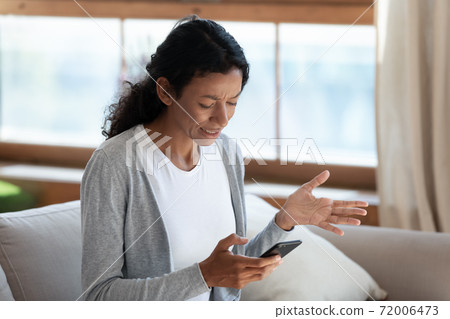 Angry biracial woman having problems with smartphone Angry biracial woman having problems with smartphone 72006473