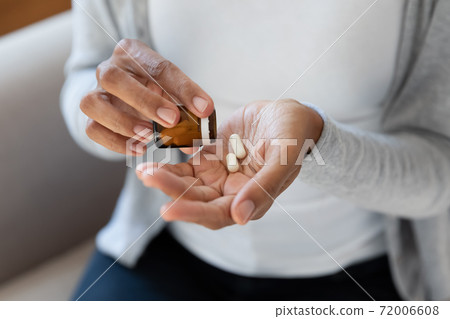 Close up of woman take medicines from bottle 72006608