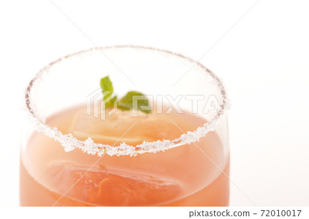 Photographed a pink salty dog with mint with salt on the edge of the glass on a white background Photographed a pink salty dog with mint with salt on the edge of the glass on a white background 72010017