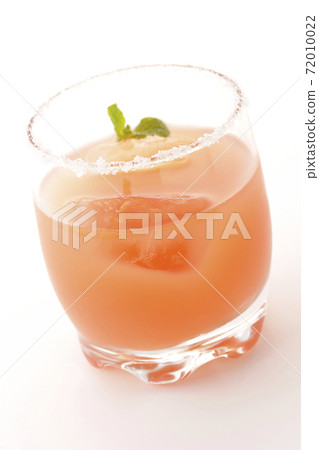 Photographed a pink salty dog with mint with salt on the edge of the glass on a white background Photographed a pink salty dog with mint with salt on the edge of the glass on a white background 72010022