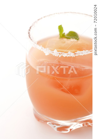 Photographed a pink salty dog with mint with salt on the edge of the glass on a white background Photographed a pink salty dog with mint with salt on the edge of the glass on a white background 72010024
