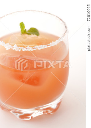 Photographed a pink salty dog with mint with salt on the edge of the glass on a white background Photographed a pink salty dog with mint with salt on the edge of the glass on a white background 72010025