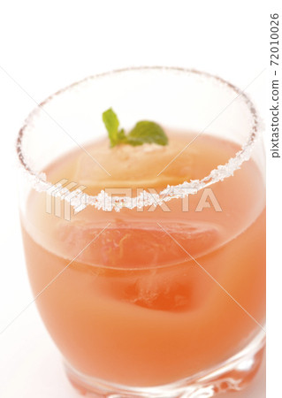Photographed a pink salty dog with mint with salt on the edge of the glass on a white background Photographed a pink salty dog with mint with salt on the edge of the glass on a white background 72010026