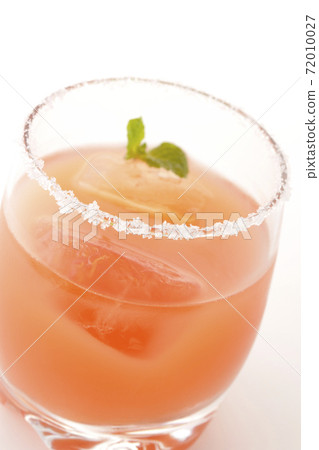 Photographed a pink salty dog with mint with salt on the edge of the glass on a white background Photographed a pink salty dog with mint with salt on the edge of the glass on a white background 72010027