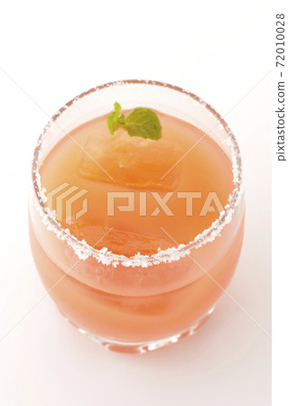 Photographed a pink salty dog with mint with salt on the edge of the glass on a white background Photographed a pink salty dog with mint with salt on the edge of the glass on a white background 72010028
