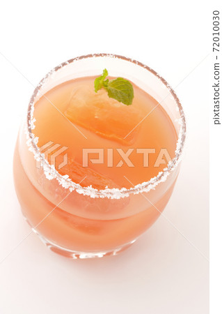 Photographed a pink salty dog with mint with salt on the edge of the glass on a white background Photographed a pink salty dog with mint with salt on the edge of the glass on a white background 72010030