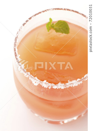 Photographed a pink salty dog with mint with salt on the edge of the glass on a white background Photographed a pink salty dog with mint with salt on the edge of the glass on a white background 72010031
