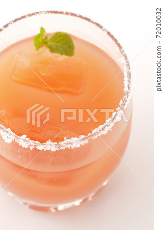 Photographed a pink salty dog with mint with salt on the edge of the glass on a white background Photographed a pink salty dog with mint with salt on the edge of the glass on a white background 72010032