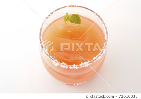 Photographed a pink salty dog with mint with salt on the edge of the glass on a white background Photographed a pink salty dog with mint with salt on the edge of the glass on a white background 72010033