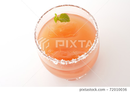 Photographed a pink salty dog with mint with salt on the edge of the glass on a white background Photographed a pink salty dog with mint with salt on the edge of the glass on a white background 72010036