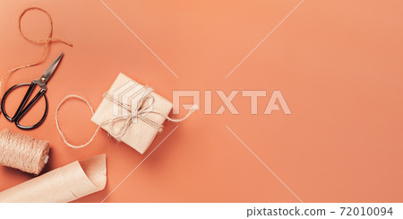 Gift box wrapped in craft paper with decor Gift box wrapped in craft paper with decor 72010094