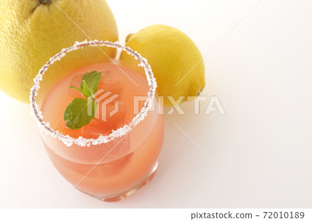 Photographed pink salty dog with mint with salt on the edge of the glass, grapefruit and lemon on a white background 72010189