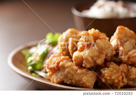 Fried chicken served on a plate photographed against a brown wooden background Fried chicken served on a plate photographed against a brown wooden background 72010283