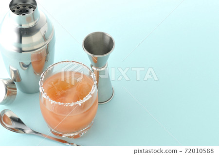 粉紅色的鹹狗,在杯,雞尾酒杯和大杯的邊緣上加鹽 粉紅色的鹹狗,在杯,雞尾酒杯和大杯的邊緣上加鹽 72010588