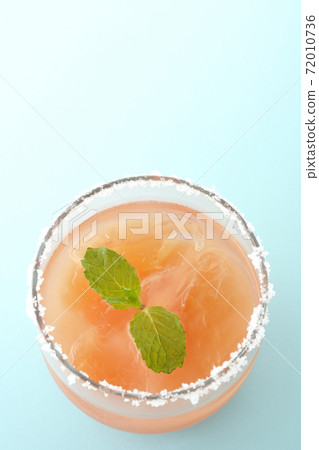 Salty dog with mint with salt on the edge of the glass (overhead view) Salty dog with mint with salt on the edge of the glass (overhead view) 72010736