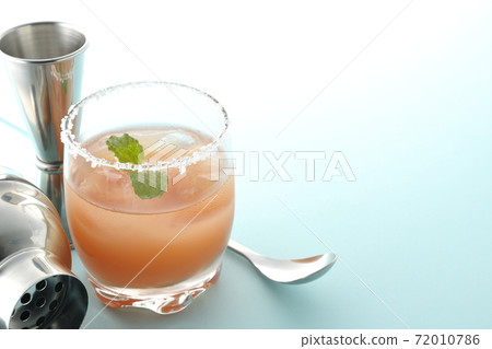 Salty dog with mint with salt on the edge of the glass, cocktail shaker and major cup Salty dog with mint with salt on the edge of the glass, cocktail shaker and major cup 72010786