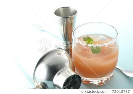 Salty dog with mint with salt on the edge of the glass, cocktail shaker and major cup Salty dog with mint with salt on the edge of the glass, cocktail shaker and major cup 72010787