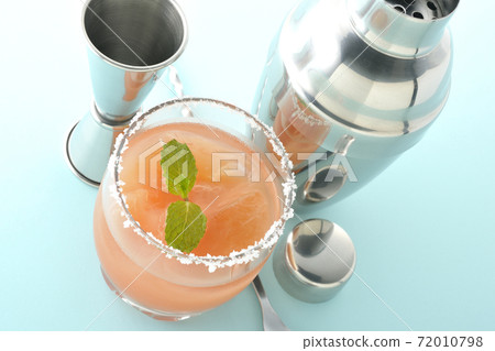 Salty dog with mint with salt on the edge of the glass, cocktail shaker and major cup Salty dog with mint with salt on the edge of the glass, cocktail shaker and major cup 72010798