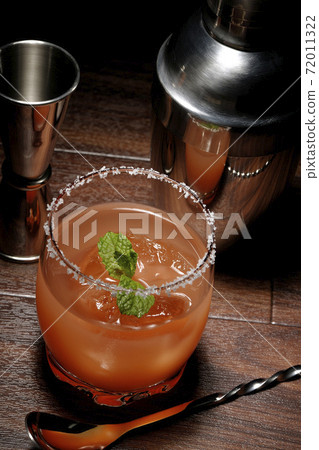 Salty dog with mint with salt on the edge of the glass, cocktail shaker and major cup Salty dog with mint with salt on the edge of the glass, cocktail shaker and major cup 72011322