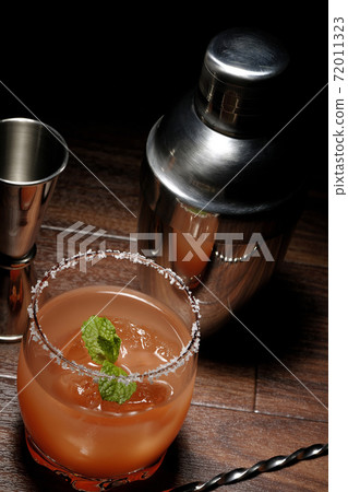 Salty dog with mint with salt on the edge of the glass, cocktail shaker and major cup Salty dog with mint with salt on the edge of the glass, cocktail shaker and major cup 72011323