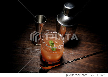 Salty dog with mint with salt on the edge of the glass, cocktail shaker and major cup Salty dog with mint with salt on the edge of the glass, cocktail shaker and major cup 72011325