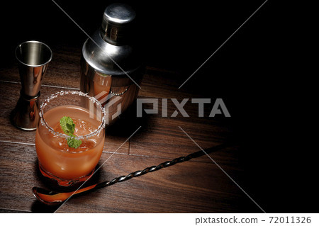 Salty dog with mint with salt on the edge of the glass, cocktail shaker and major cup 72011326