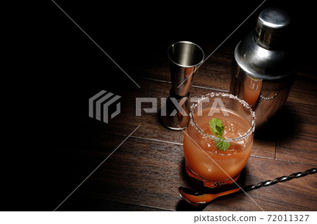 Salty dog with mint with salt on the edge of the glass, cocktail shaker and major cup Salty dog with mint with salt on the edge of the glass, cocktail shaker and major cup 72011327