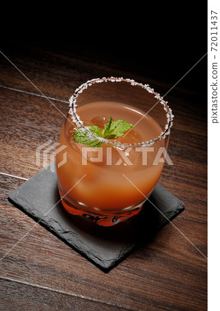 Pink salty dog with mint with salt on the edge of the glass placed on the slate plate Pink salty dog with mint with salt on the edge of the glass placed on the slate plate 72011437