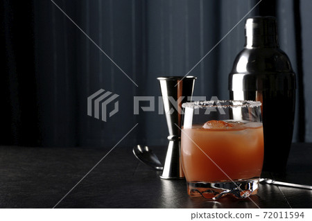 Salty dog with salt on the edge of the glass, cocktail shaker and major cup Salty dog with salt on the edge of the glass, cocktail shaker and major cup 72011594