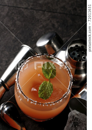 Salty dog with mint with salt on the edge of the glass, cocktail shaker and major cup Salty dog with mint with salt on the edge of the glass, cocktail shaker and major cup 72011631