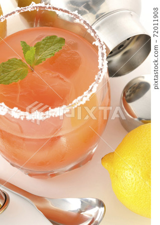 Salty dog with mint with salt on the edge of the glass, cocktail shaker and bar spoon 72011908