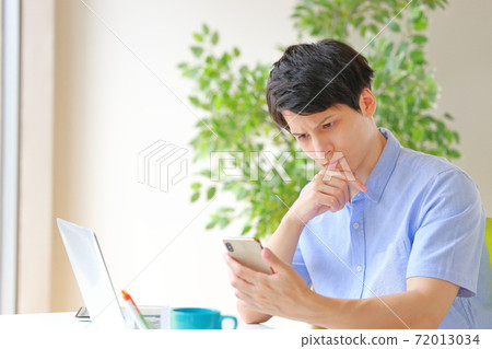 看著智能手機和眉毛之間的皺紋的商人 看著智能手機和眉毛之間的皺紋的商人 72013034