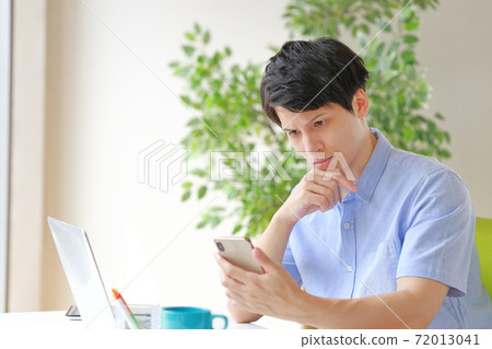 A businessman who is stuffy looking at a smartphone A businessman who is stuffy looking at a smartphone 72013041