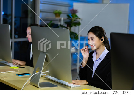 Asian young woman working overtime late at night in call center office. Asian young woman working overtime late at night in call center office. 72013771