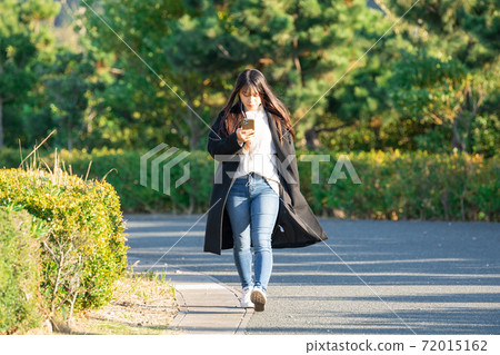 Smartphone earphone park walk woman 72015162