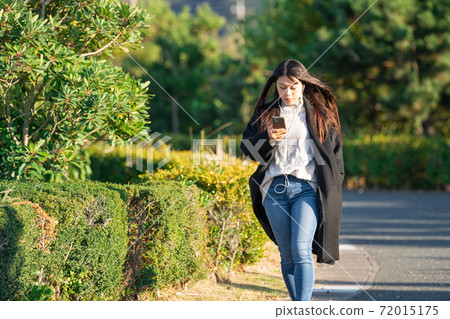 Smartphone earphone park walk woman 72015175