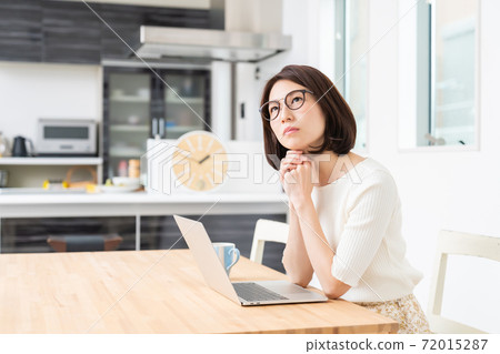 Thinking a woman watching a computer Thinking a woman watching a computer 72015287
