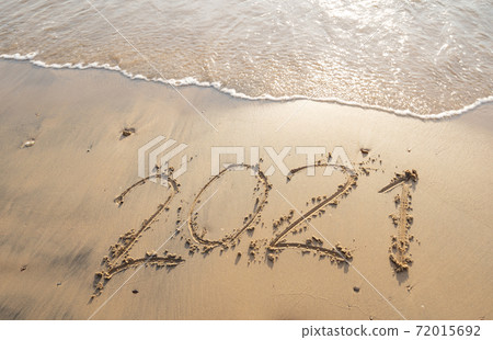 Sea wave wipe away 2021 Text writing on white sand Tropical beach in the morning Beautiful light sunrise on beach and wave crashing on sandy shore. 72015692