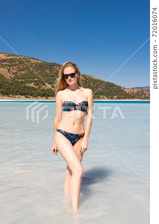 Teenager Girl Wearing Bikini Stands In The Water Of A Beautiful