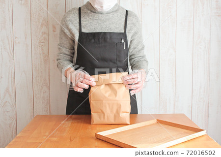 女店員把產品放在紙袋裡 女店員把產品放在紙袋裡 72016502