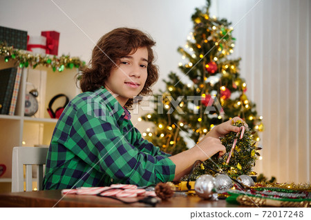 Teenage boy making Christmas decoration 72017248