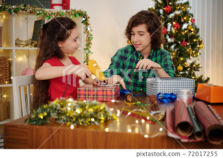 Siblings wrapping presents 72017255
